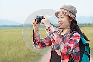 Asian tourist woman taking photo by digital camera on nature mountain view. A young girl is traveling on summer vacation