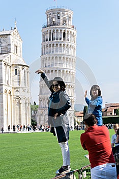 Asian tourists take pictures of the Leaning Tower of Pisa