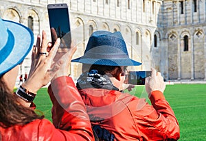 Asian tourists take pictures of the Leaning Tower of Pisa