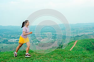 Asian trail runners, women  wearing sportswear are practicing on a high mountain running. During the evening when the air is fresh