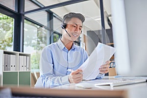 Asian translator or business man with headset smiling while sitting in office. Accountant checking documents, preparing