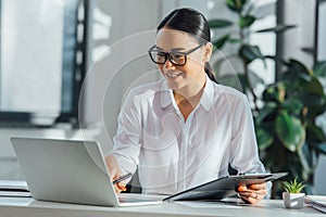 Asian translator in eyeglasses working online