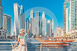 Asian traveler girl walking on a promenade in Dubai Marina district. Travel destinations and tourist lifestyle in UAE