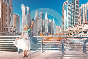 Asian traveler girl walking on a promenade in Dubai Marina district. Travel destinations and tourist lifestyle in UAE