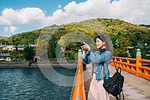 An asian traveler taking photo on the bridge