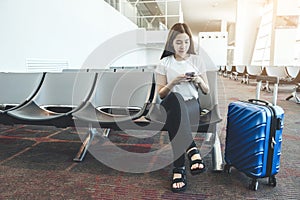 Asian Traveler women looking for flight in smartphone at airport terminal Travel concept