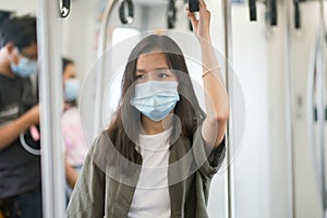 Asian travelers girl in train with medical face mask to protection the Covid-19, new normal lifestyle