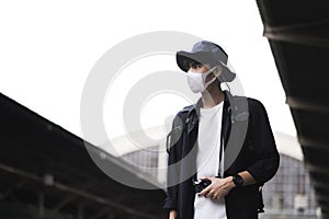 Asian travelers men and camera in train station with medical face mask to protection the Covid-19, new normal lifestyle