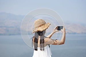 Asian travelers taking pictures with mobile phones, Thailand dam