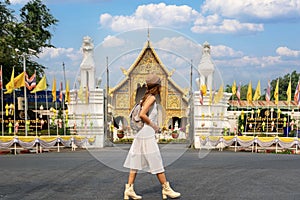 Asian traveller walking on street infront of wat phra singh temple