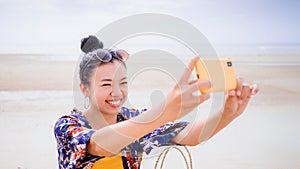 Asian traveller woman sit back and relax on the beach by the sea background on weekend vacation.Concept of happy solo travel