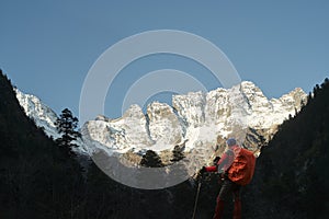 Asian trekker looking at mount jiawaren-an of the meili snow mountains, china