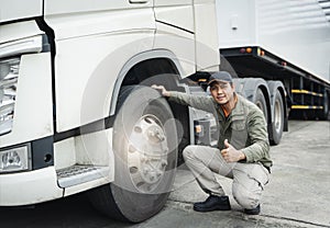 Asian Truck Driver Giving Thumb-Up and Checking Semi Truck Wheels Tires. Truck Inspection Maintenance and Safety Driving