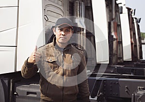 Asian A Truck Driver Looking and Giving Thumb-Up with Semi Truck. trucker. Transport and Logistics.