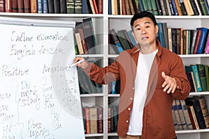 Asian Tutor Talking Pointing At Whiteboard Having Remote Class Indoors