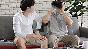 Asian two age generations men family old father playing video games virtual reality glasses