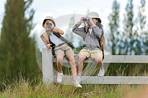 Asian two friend children take a photo and see binoculars for adventure and tourism for destination and leisure trips for educatio photo