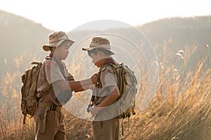 Asian two scouts check each other`s attire before making the long journey to Scout camp