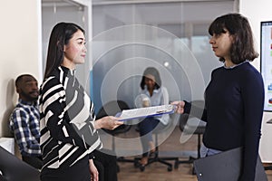 Asian unemployed woman giving CV resume to human resources manager in order to get interviewed.