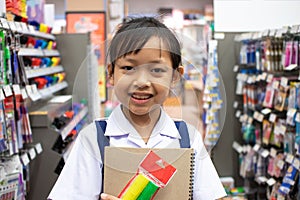 Asian uniform student girl in stationery store buying pens and school supplies.Back to school concept