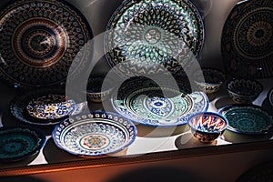 asian Uzbek handmade ceramic plates and bowl with hand-painted traditional patterns in pottery workshop in Uzbekistan