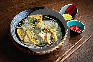 Asian vegetarian noodle soup in a ceramic plate