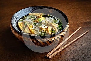 Asian vegetarian noodle soup in a ceramic plate