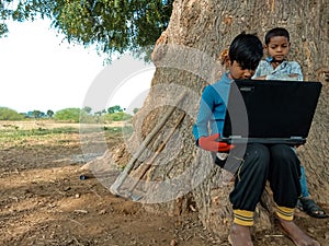 Asian village kids operating laptop at natural background in india January 2020