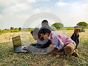 Asian village kids operating laptop at natural background in india January 2020