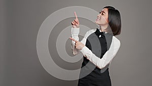 Asian waitress pointing up for an advertisement in studio