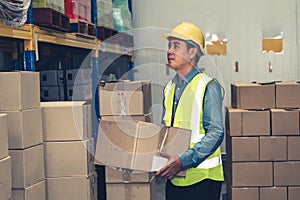 Asian warehouse worker checking packages in storehouse
