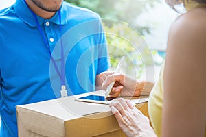 Asian woman accepting receive a delivery of boxes from delivery asian man