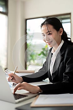 Asian woman accounting sit at their desks and calculate financial graph showing results about their investment, planning