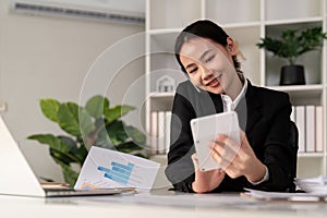 Asian woman accounting sit at their desks and calculate financial graph showing results about their investment, planning