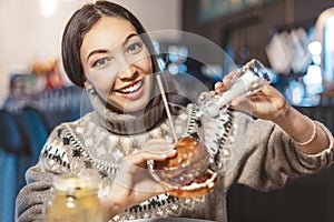 Asian woman adds more sea food salt to her fast food burger at a restaurant. Excessive abuse of salt and seasonings and