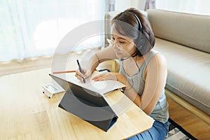 Asian woman aged 30-35 years using tablet, watching lesson online course communicate by conference video call from home, e-