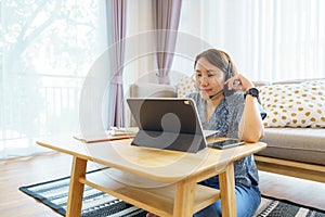 Asian woman aged 30-35 years using tablet, watching lesson online course communicate by conference video call from home, e-