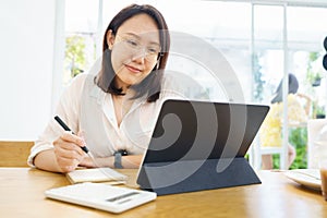 Asian woman aged 30-35 years using tablet, watching lesson online course communicate by conference video call from home, e-