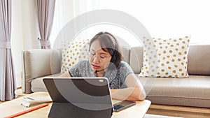 Asian woman aged 30-35 years using tablet, watching lesson online course communicate by conference video call from home, e-learnin