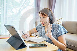 Asian woman aged 30-35 years using tablet, watching lesson Sign language online course communicate by conference video call from