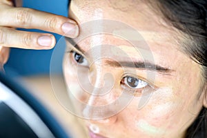 Asian woman applying makeup, Cosmetics foundation using to correcting or hiding facial skin problem.