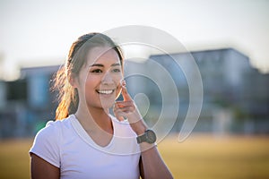 Asian Woman applying and spraying sunscreen cream on skin before run. Sports and healthy concept