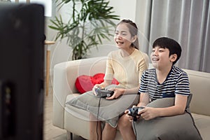 Asian woman with asian boy playing video games at home