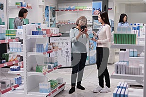 Asian woman and assistant looking at smartphone