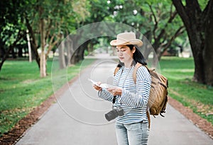 Asian woman backpack traveler use map when traveling at rain forest.Holiday vacation concept.journey lifestyle.solo travel