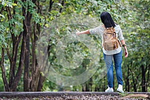 Asian woman backpacker standing on countryside road with tree in