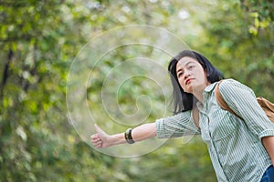 Asian woman backpacker standing on countryside road with tree in