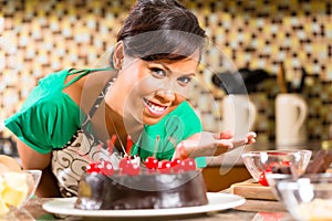 Asian woman baking chocolate cake in kitchen