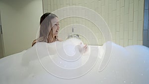 Asian woman in bath tub playing with bubble. female enjoy soft foam in bath room.