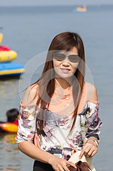 Asian woman in beautiful hat on tropical beach